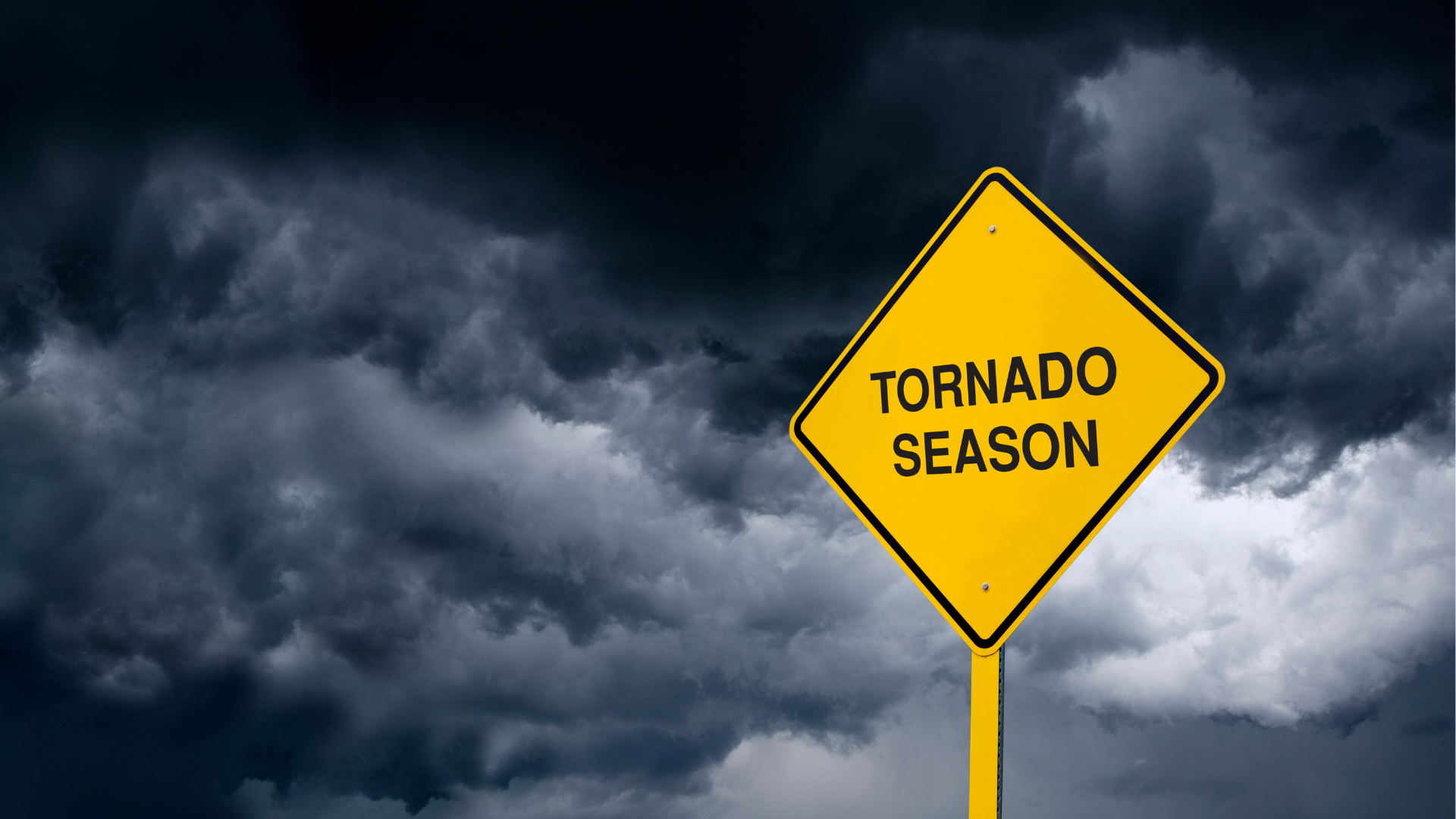 yellow sign reads "tornado season" with stormy background